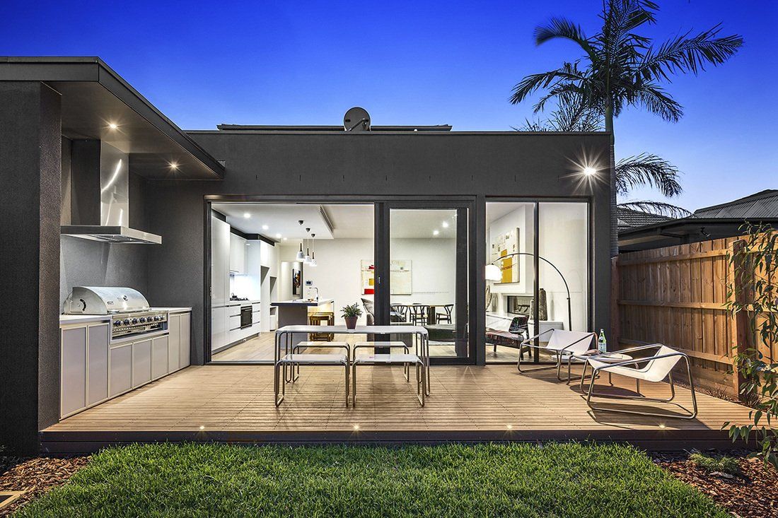 The back of a house with a patio and a grill.