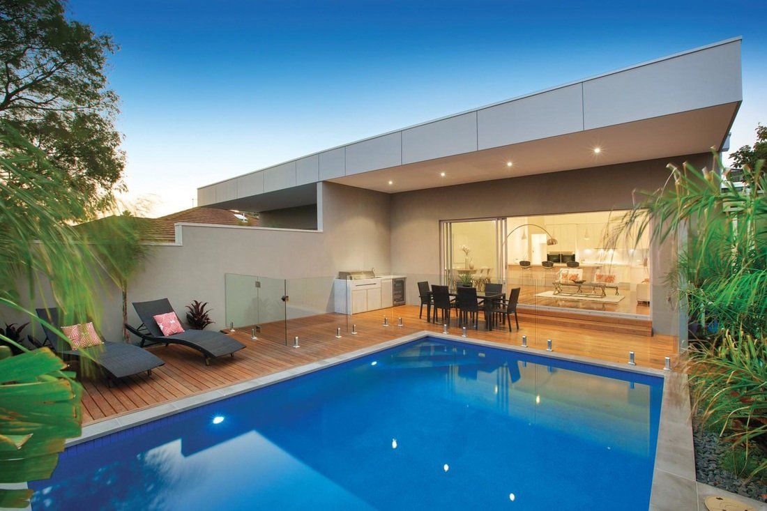 A house with a large swimming pool in front of it