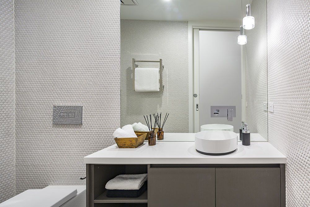 A bathroom with a sink , mirror and toilet.