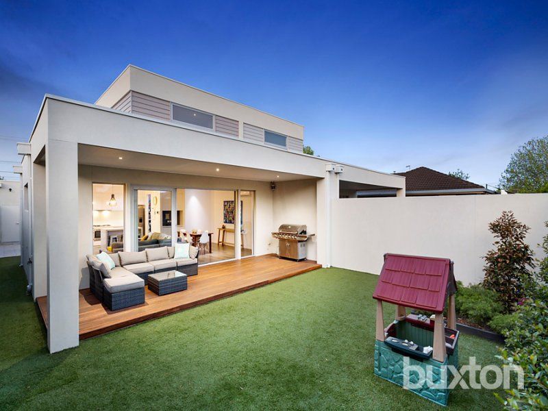 A house with a patio and a playhouse in front of it