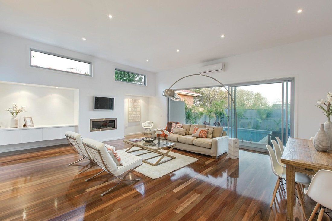 A living room with a couch , chairs , table and television.