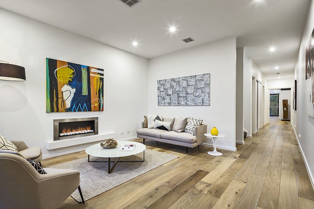 A living room with a couch , chairs , coffee table and fireplace.