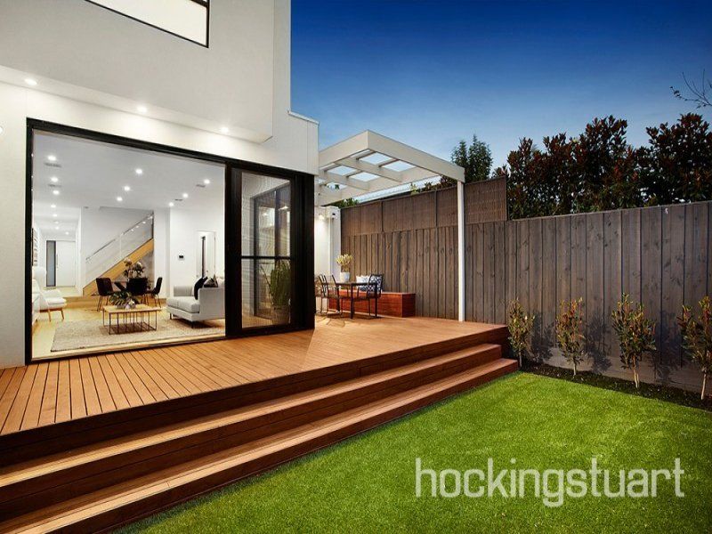 The backyard of a house with a wooden deck and stairs