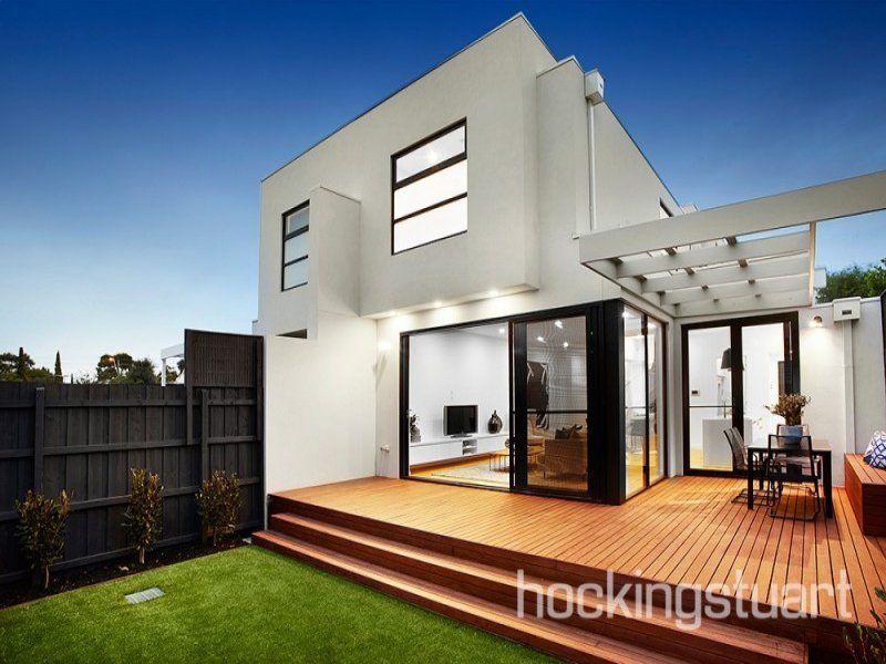 A white house with a wooden deck in front of it