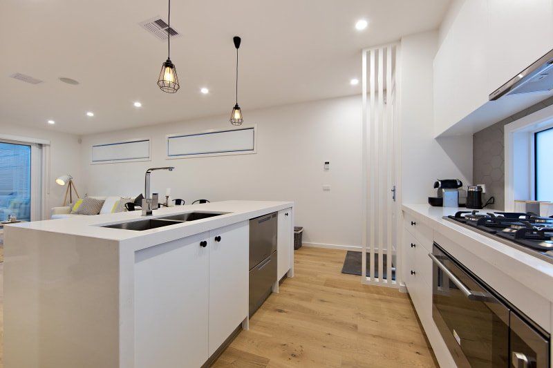 A kitchen with white cabinets and stainless steel appliances.