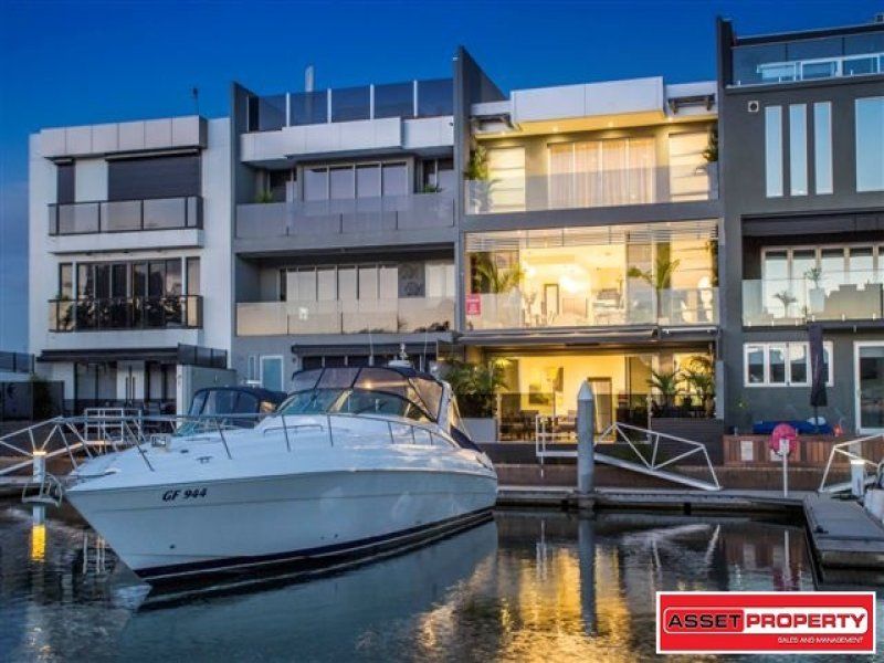 A boat is docked in front of a building with a sign that says asset property