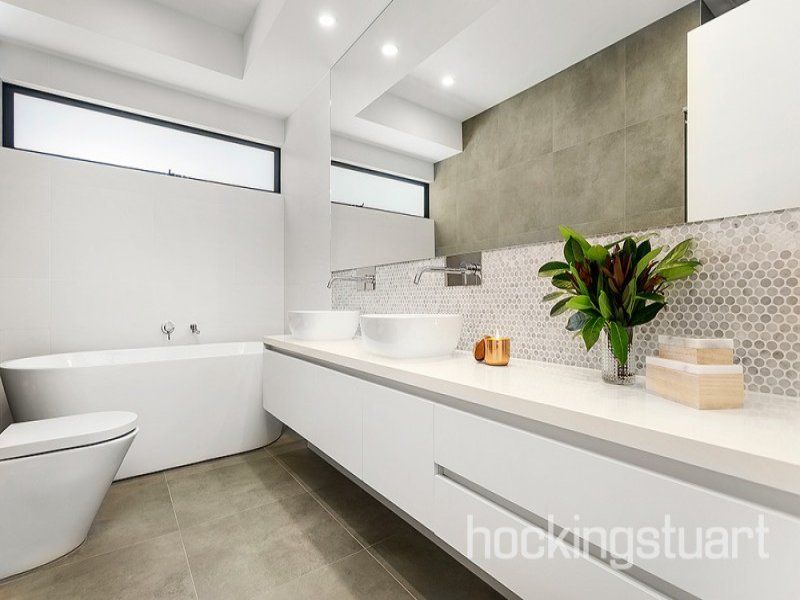A bathroom with two sinks a toilet and a bathtub