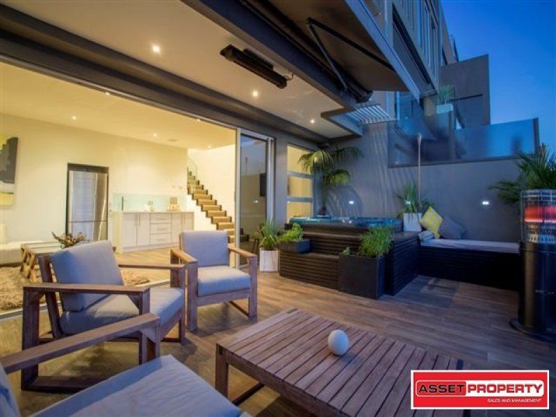 A patio with chairs a table and a sign that says asset property