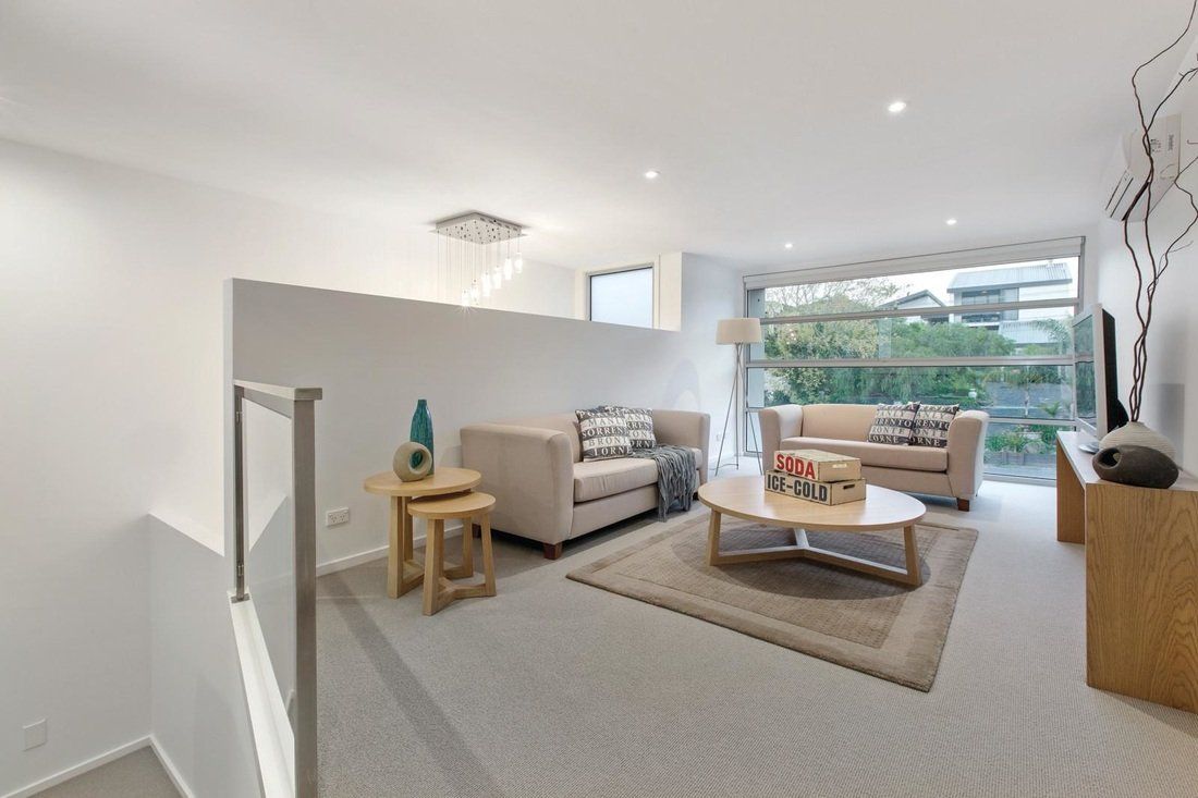 A living room with a couch , coffee table , and television.