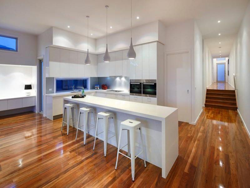 A modern kitchen with a long island and stools