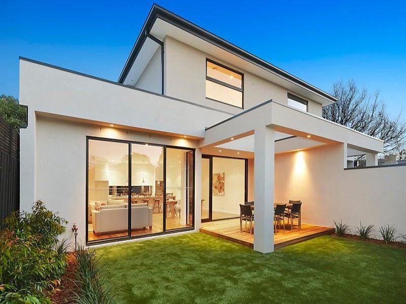 A white house with a large lawn in front of it