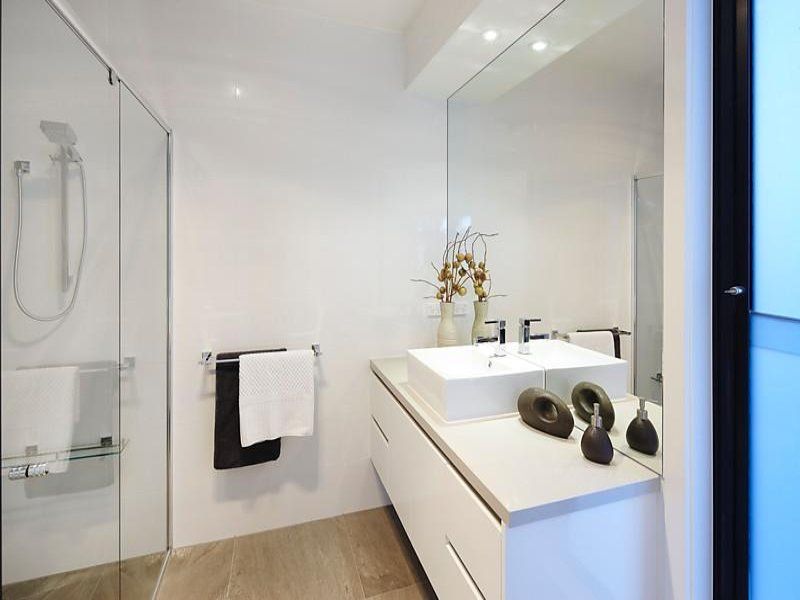 A bathroom with a sink a mirror and a walk in shower