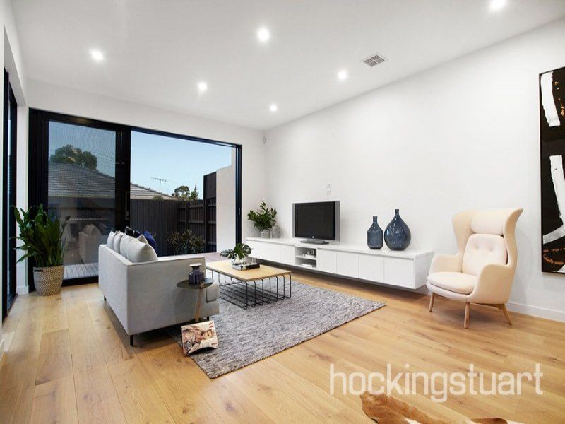 A living room with a couch a chair and a flat screen tv