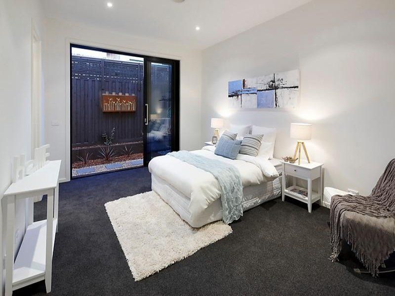 A bedroom with a large bed and a sliding glass door
