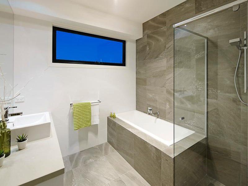 A bathroom with a bathtub , sink , and shower.