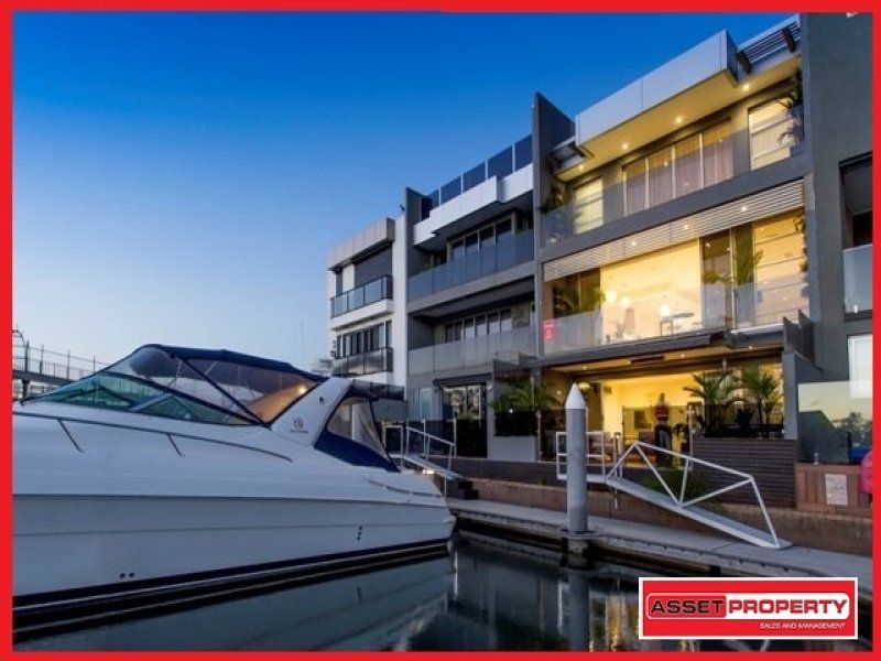A boat is docked in front of a building.
