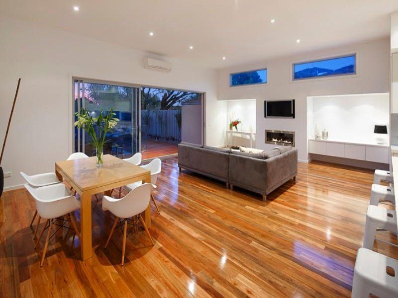 A living room with hardwood floors and a table and chairs
