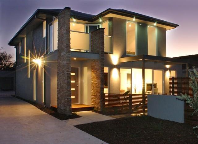 A house with a lot of windows is lit up at night