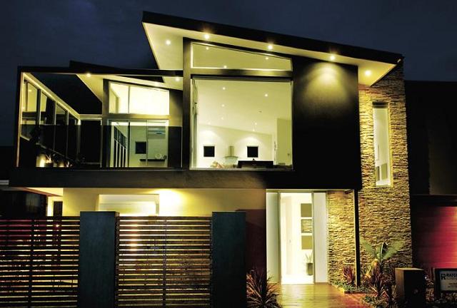 A house with a lot of windows is lit up at night