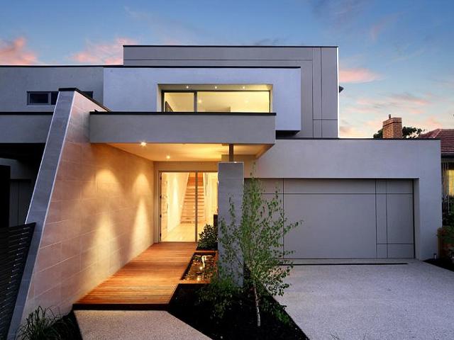 A modern house with a wooden walkway leading to it