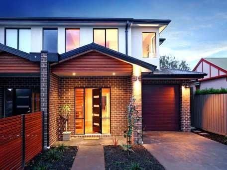 A brick house with a garage and a wooden fence
