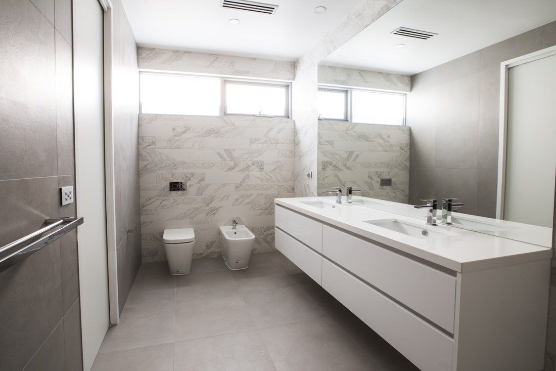 A bathroom with two sinks , a toilet and a bidet