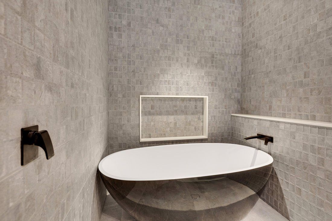 A bathroom with a bathtub and a mirror on the wall.