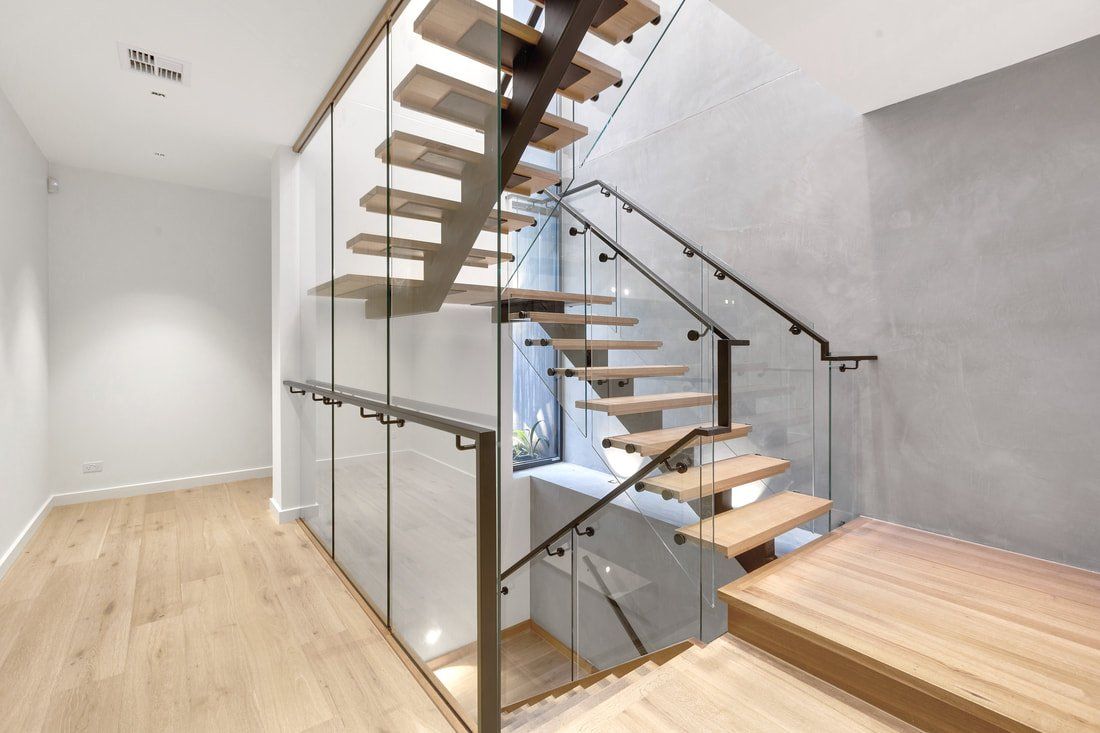 A modern staircase with wooden steps and a glass railing.