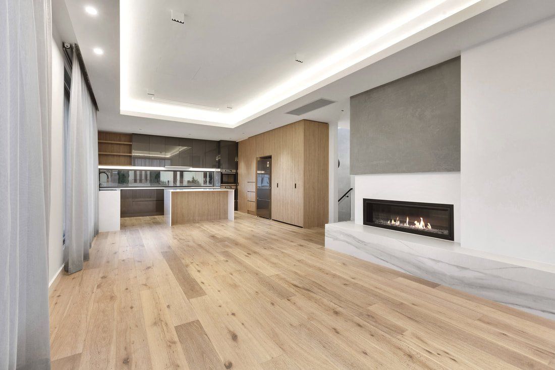 An empty living room with hardwood floors and a fireplace.