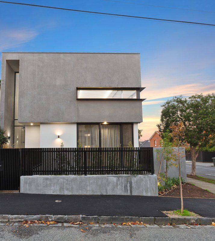 A modern house with a black fence in front of it