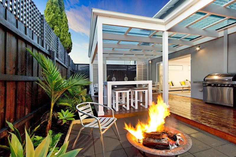 There is a fire pit in the backyard of a house.