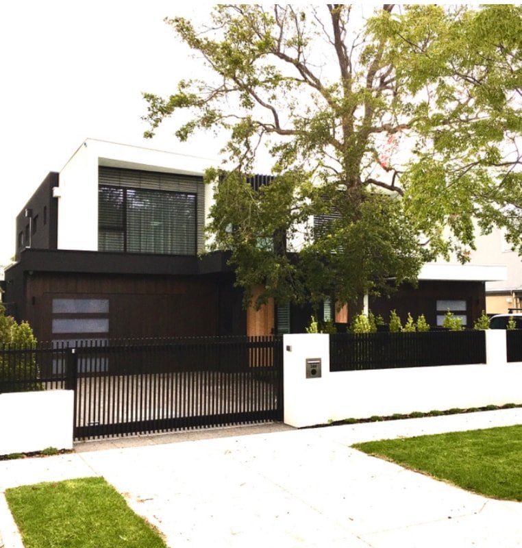 A black and white house with a fence around it