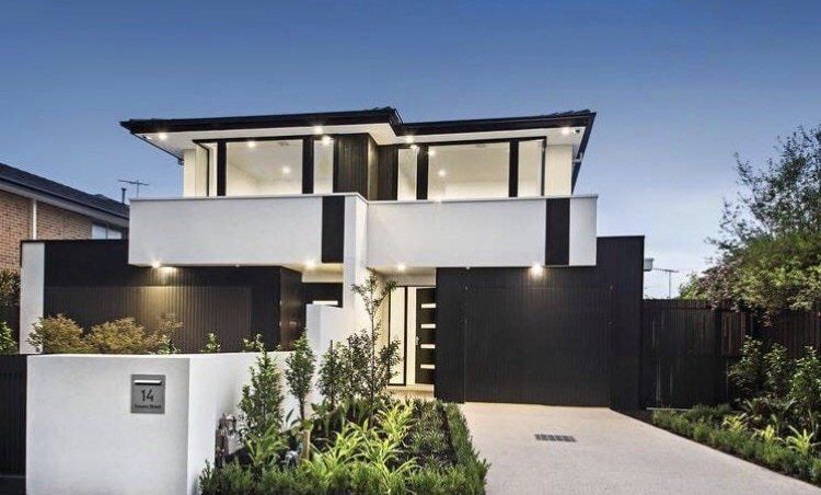 A black and white house with a mailbox in front of it