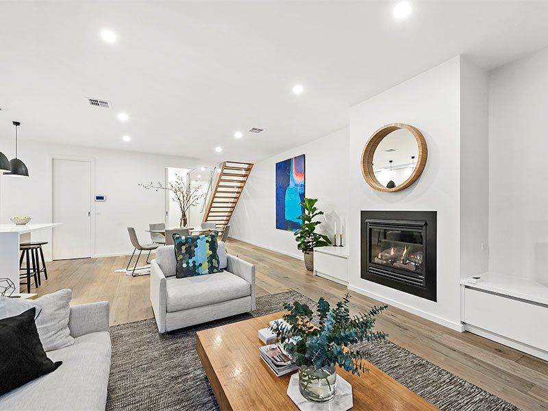 A living room with a couch , chair , coffee table and fireplace.