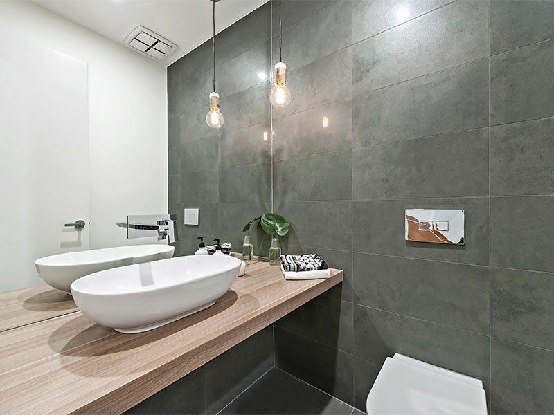 A bathroom with two sinks and a toilet