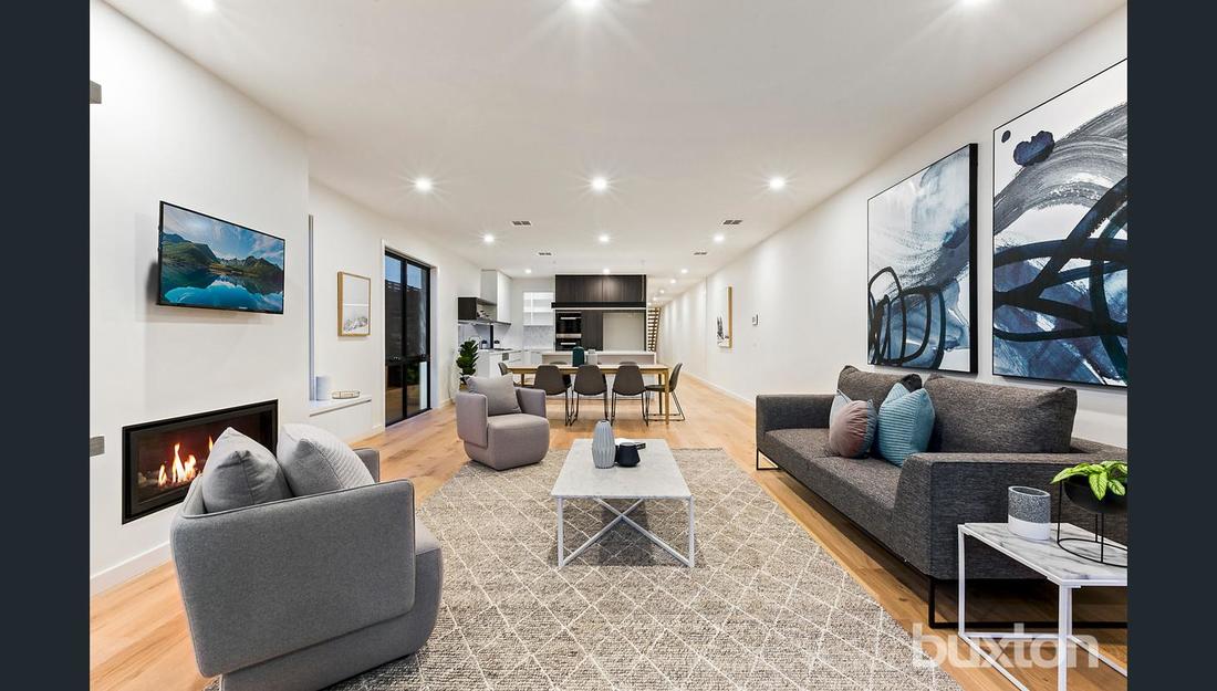 A living room with a couch , chairs , coffee table and fireplace.