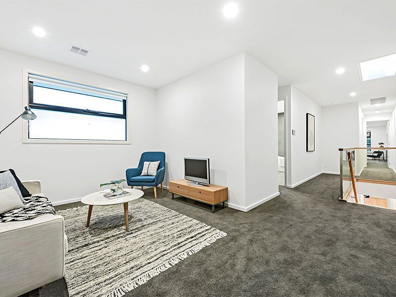 A living room with a couch , chair , table and television.