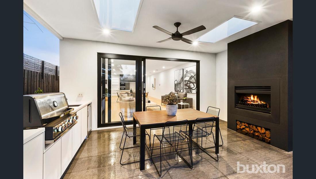 A dining room with a table and chairs and a fireplace.
