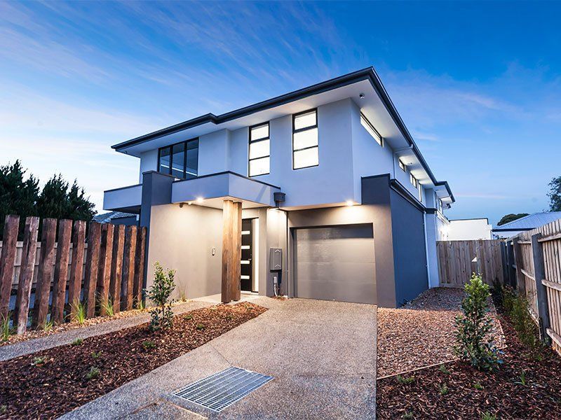 A modern house with a garage and a wooden fence
