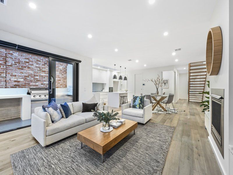 A living room with a couch , chair , coffee table and fireplace.