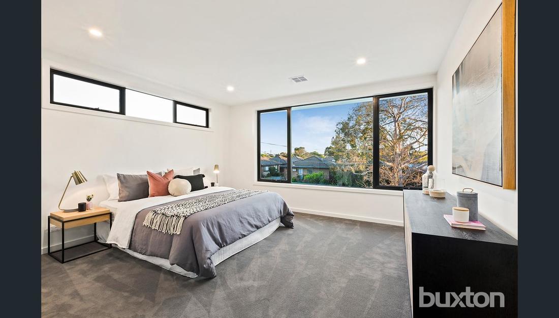 A bedroom with a large bed and a large window.
