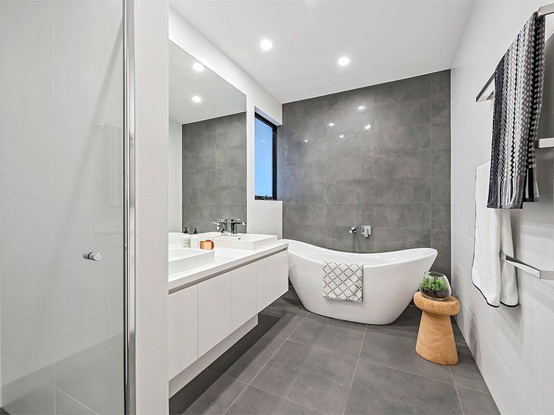 A bathroom with a bathtub , sink , mirror and shower.