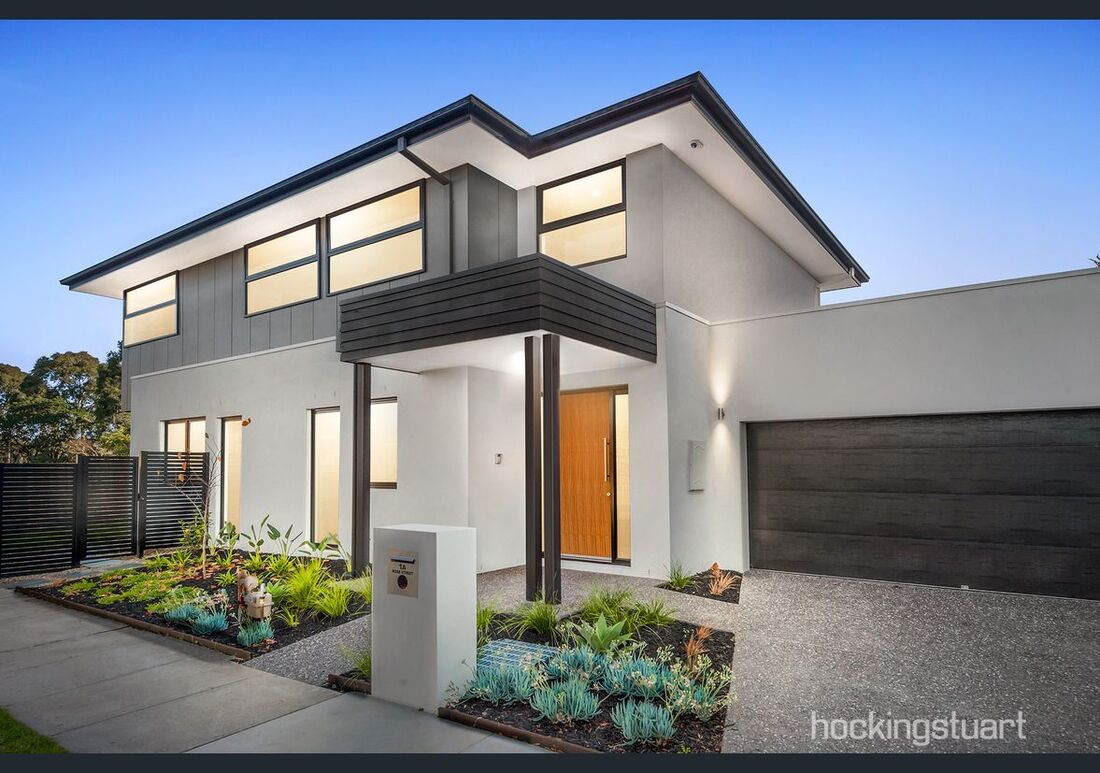 A large white house with a black garage door