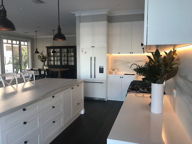 A kitchen with white cabinets and a stove top oven