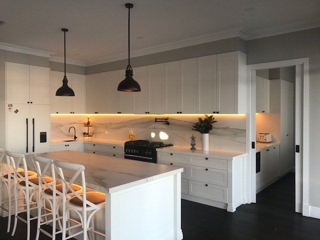 A kitchen with white cabinets and a large island
