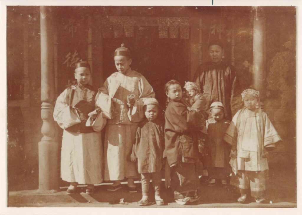 Seven children stand in front of the temple in Napa's Chinatown in 1896, with their father Chan Wah Jack standing behind them.