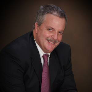 A man in a suit and tie is smiling for the camera.