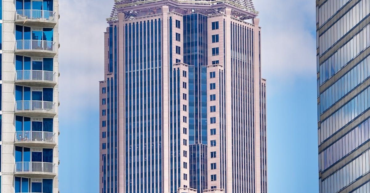 A tall building with a lot of windows is in the middle of a city.