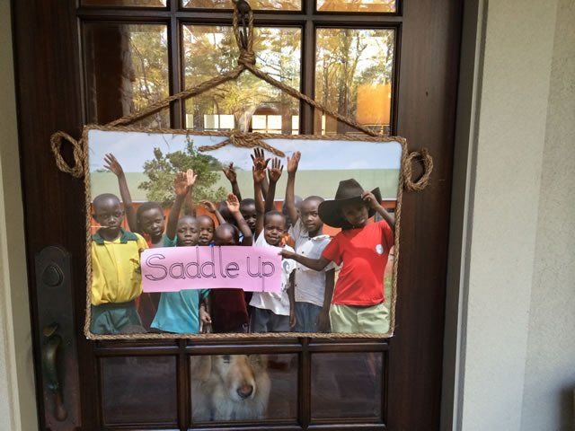 Sign on a door: Group of Black children with raised arms, the sign reads 