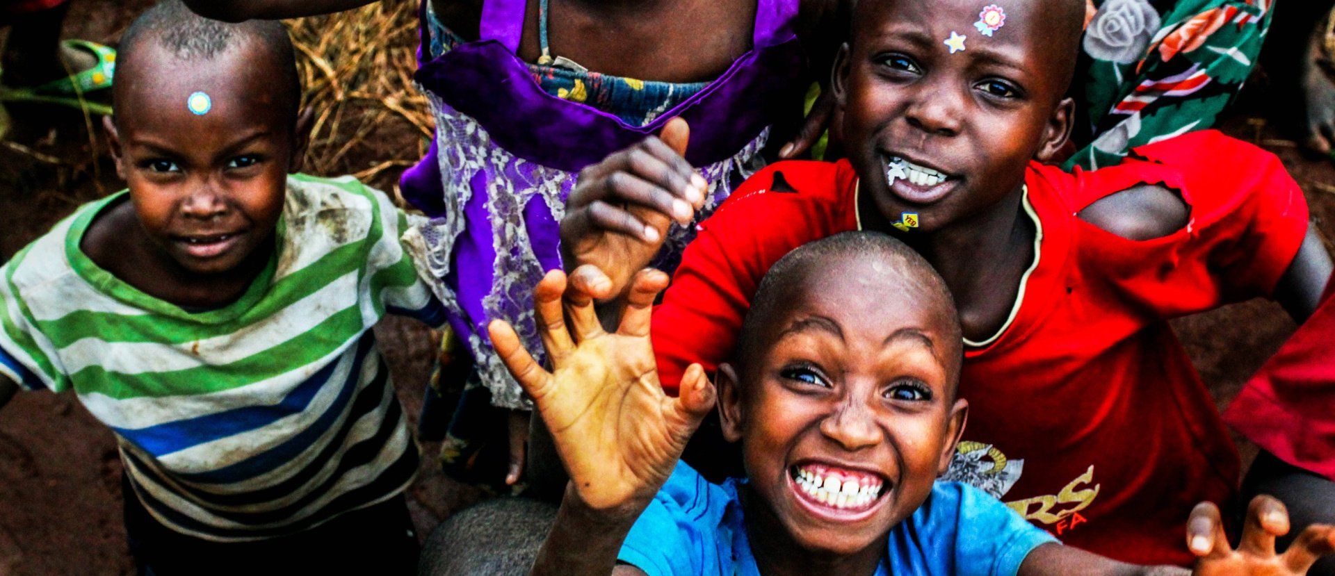A group of children are standing next to each other and smiling.